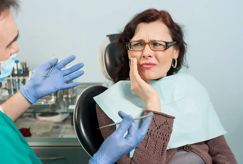 Dentist explaining a root canal procedure to a patient using a digital X-ray at Village Dental in Wake Forest, NC