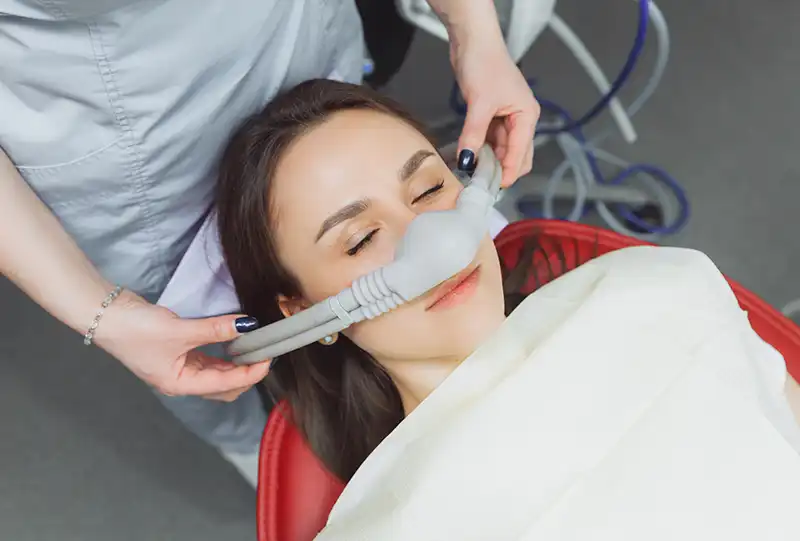 Dentist monitoring a sedated patient's vitals during oral conscious sedation at Village Dental Brier Creek, Raleigh, NC